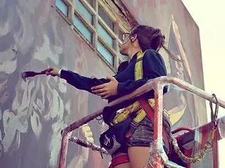 Milu Correch painting a mural