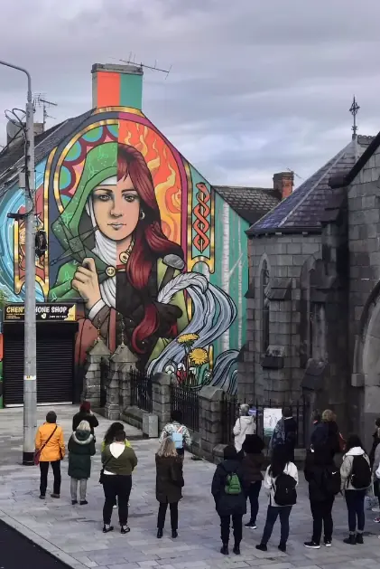 Visitors gathered beside Friz’s Brigid of Faughart mural