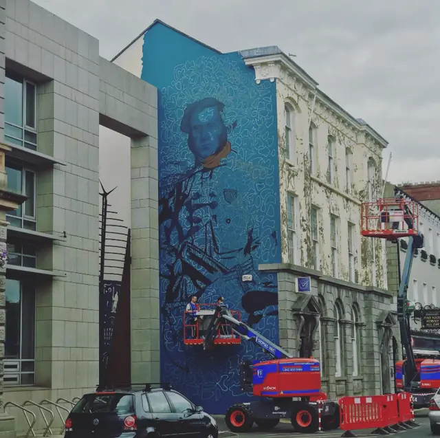 Aches’s blue Edward de Bruce mural being painted using elevated work platforms